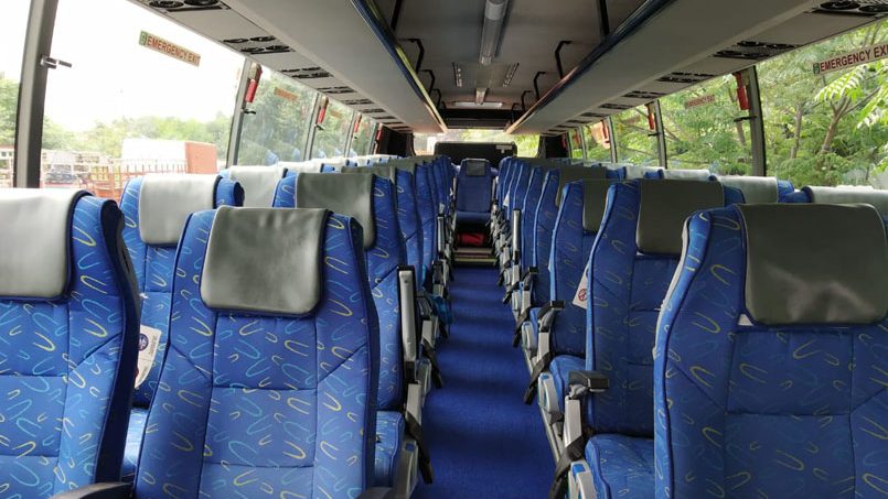Comfortable blue bus seats with headrests inside a Singapore charter bus for group travel.